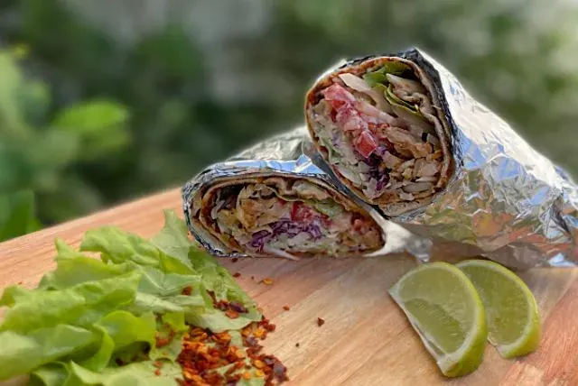 Lahmacun enrollados con carne, verduras frescas y lima